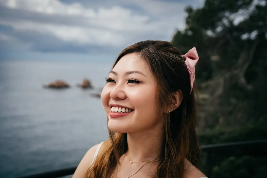She laughs, the coast behind her